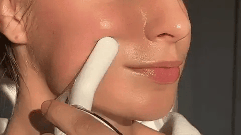Close-up GIF of Skin Revive facial massager gliding over the cheek to boost serum absorption, revealing glowing and dewy skin texture.