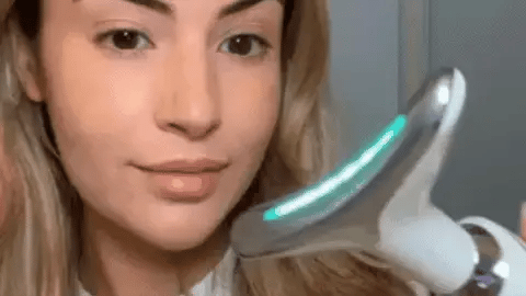 Woman using the Skin Revive anti-ageing LED face and neck massager, demonstrating the 7 colour light therapy modes for at-home skin rejuvenation.