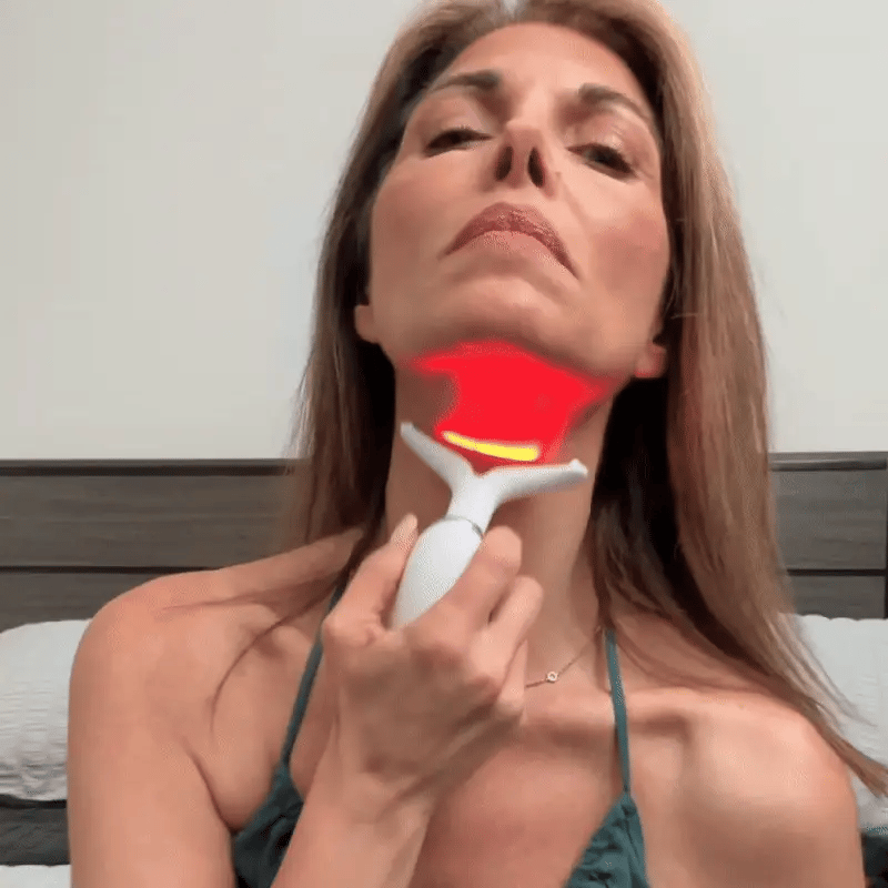 Mature woman using the Skin Revive device to target turkey neck, featuring a graphic demonstrating deep red light therapy and heat penetration for skin tightening.